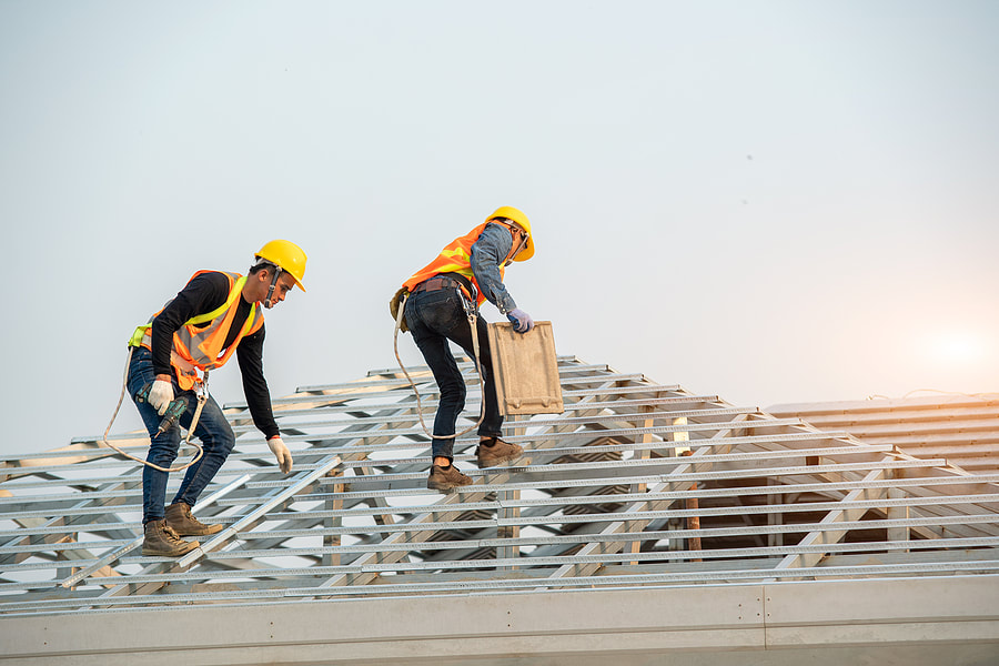 two workers repairing the roof