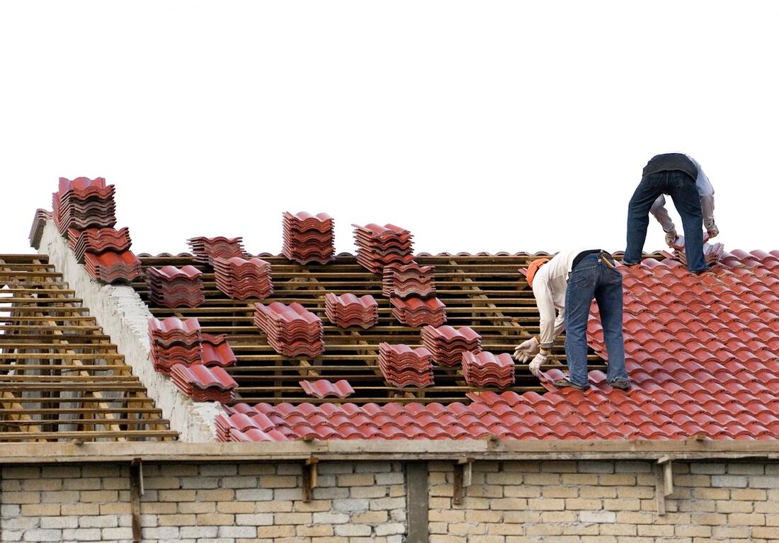 two workers installing roof tile